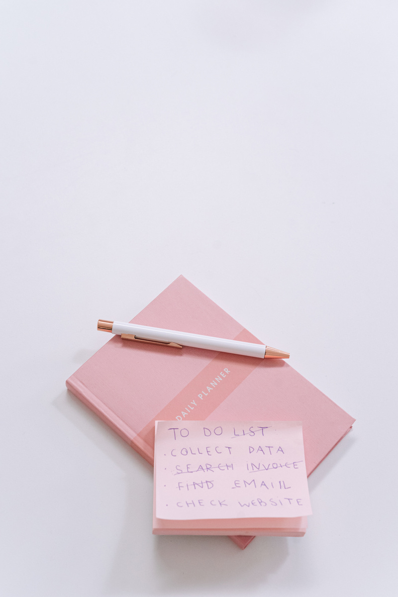 Pink Sticky Notes and Notepad on White Surface